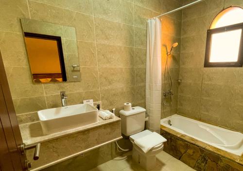 a bathroom with a toilet and a sink and a tub at SAMA Jabal Samhan Hotel in Salalah