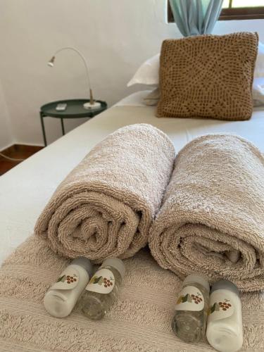 a bed with towels and slippers on a bed at Casa Lavadeira - VINHAS de NEXE in Faro