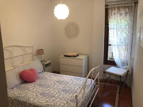 ein Schlafzimmer mit einem Bett mit einem Herzkissen drauf in der Unterkunft La fuenta in Málaga