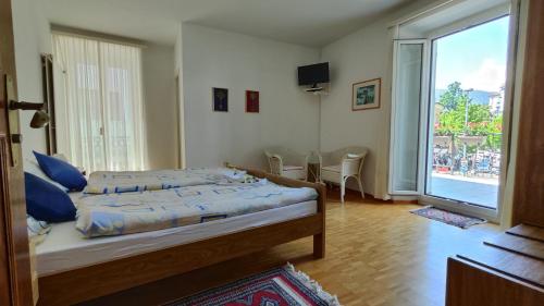 a bedroom with a bed and a large window at Hotel Scaletta in Locarno