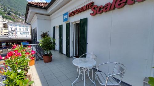 a balcony with a table and chairs on a building at Hotel Scaletta in Locarno