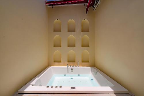 una vasca da bagno in una stanza con archi di Stay Vista at Khohar Haveli - 18th Century Palace with Modern Amenities a Gurgaon