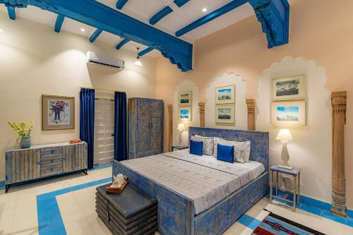 a bedroom with a blue bed in a room at Stay Vista at Khohar Haveli - 18th Century Palace with Modern Amenities in Gurgaon