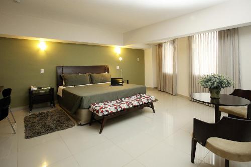 a bedroom with a bed and a table and chairs at Ipe Center Hotel in Sao Jose do Rio Preto