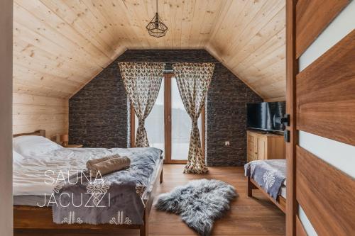 1 dormitorio con cama y pared de ladrillo en Gorczański Resort Domek w Górach Sauna Jacuzzi, en Nowy Targ