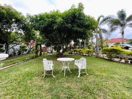 three chairs and a table in the grass at Villa 70C in Dharga Town