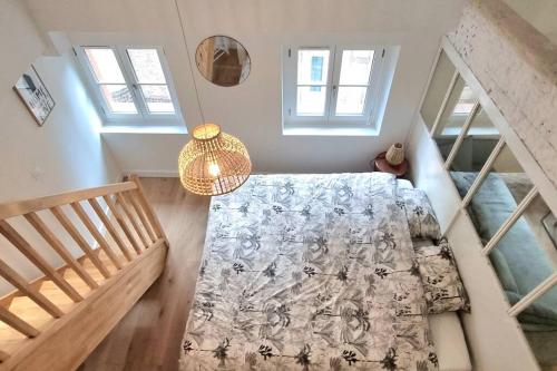 - une chambre avec un lit et un escalier avec des fenêtres dans l'établissement Dans les nuages - T2 Spacieux Standing - Metro - Wifi, à Toulouse