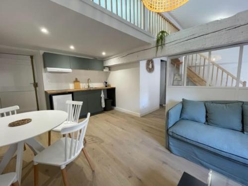 un salon avec un canapé bleu et une table dans l'établissement Dans les nuages - T2 Spacieux Standing - Metro - Wifi, à Toulouse