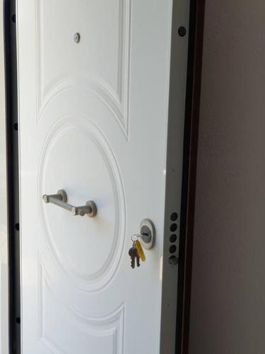 a white door with a lock and a key at Konstantinos Apartmend Chalkidiki in Sozopoli
