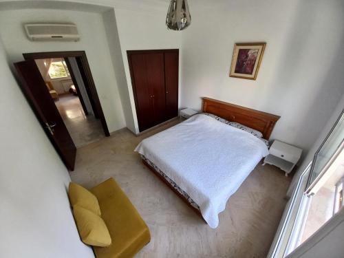 1 dormitorio pequeño con 1 cama y 1 silla en Confort Inn Lac 2, en Túnez