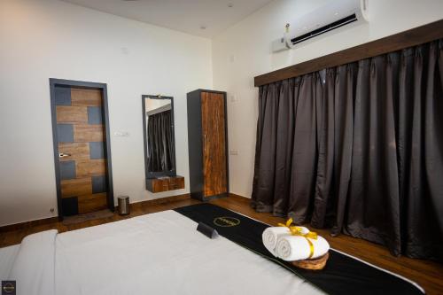 a bedroom with a bed and a window with black curtains at Reunion Ocean Manor - Beach House in Udupi
