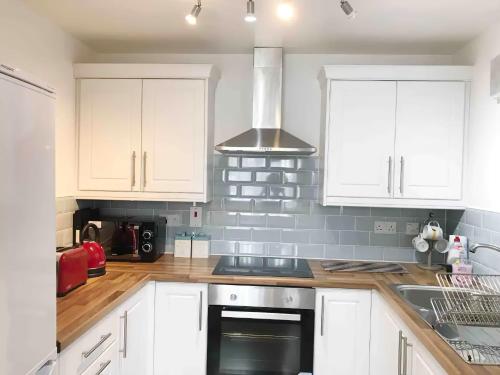 a kitchen with white cabinets and a stove top oven at City Centre Vintage Theme Guest Rooms Free Parkin in Liverpool