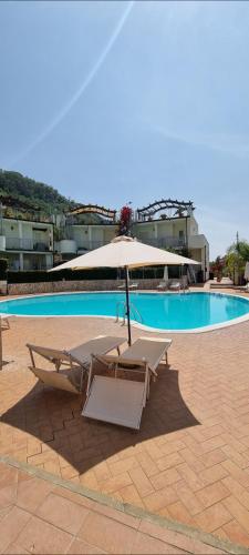 a pair of lounge chairs and an umbrella next to a pool at MAGIK hill in Pizzo