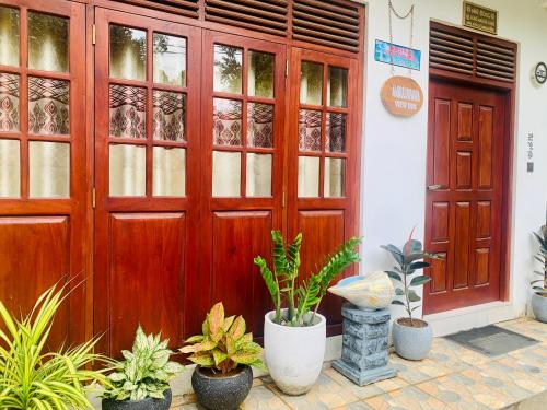 a wooden door with plants in front of a building at Ambuluwawa View Inn in Gampola