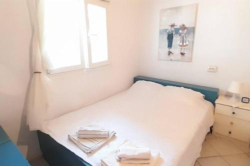 a small bedroom with a bed with a window and a picture at Μονοκατοικία Καλλικράτεια in Nea Kallikrateia
