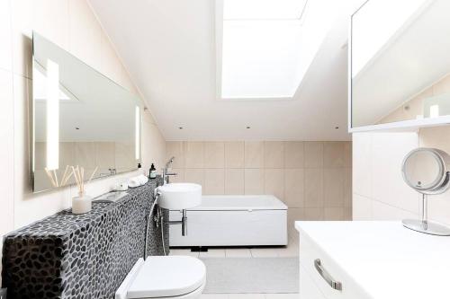 a bathroom with a sink toilet and a mirror at Stunning Huvilakatu Penthouse in Helsinki