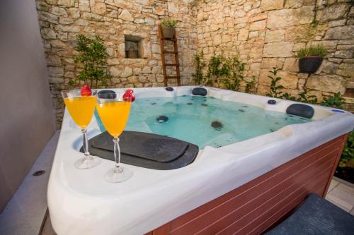 2 verres de jus d'orange assis sur une baignoire dans l'établissement CASA MARIO-charming stone house with jacuzzi, à Svetvinčenat