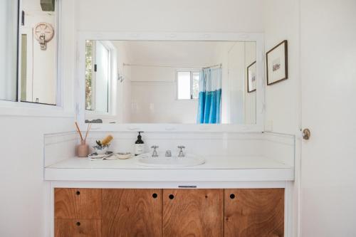 a bathroom with a white sink and a mirror at Hillhouse in Point Lookout