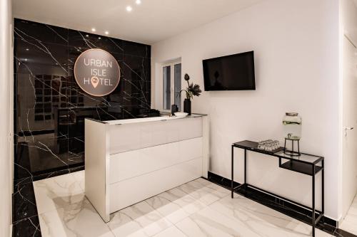 a room with a white counter and a tv on a wall at Urban Isle in Il-Gżira