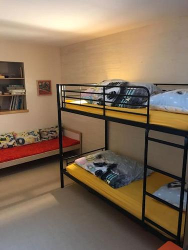 une chambre avec trois lits superposés dans une pièce dans l'établissement Maison au calme, à Eyravazet