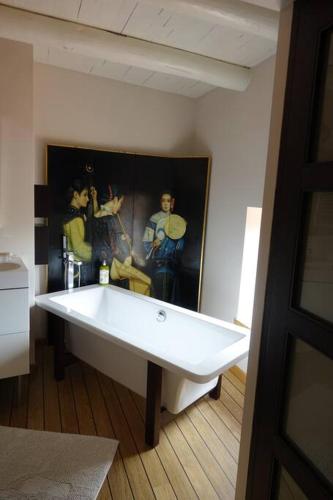 d'une baignoire dans une pièce ornée d'une peinture murale. dans l'établissement Maison au calme, à Eyravazet