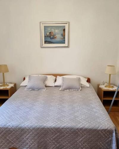 a bed in a bedroom with two lamps and a picture on the wall at Antonny apartment in Zvekovica