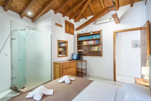 a bedroom with a bed and a glass shower at ELIZA Skiathos in Skiathos Town