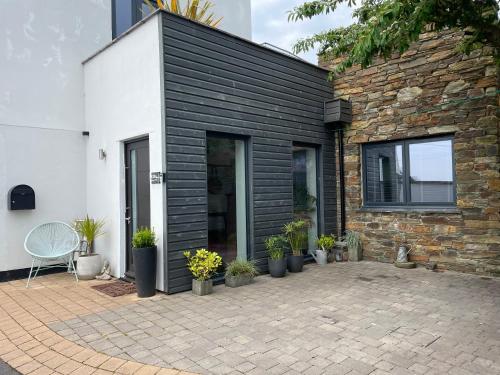 una casa de ladrillo con un patio con macetas en Beautiful Townhouse with Parking Sleeps 6, en Kingsbridge