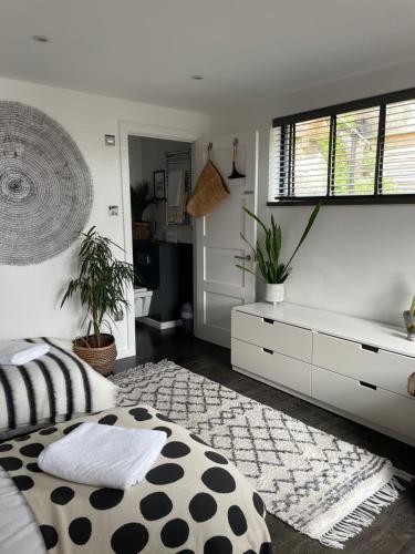a bedroom with a bed and a dresser with plants at Beautiful Townhouse with Parking Sleeps 6 in Kingsbridge