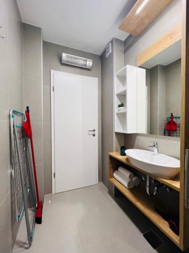 a bathroom with a white door and a sink at Apartmani AViS in Selce