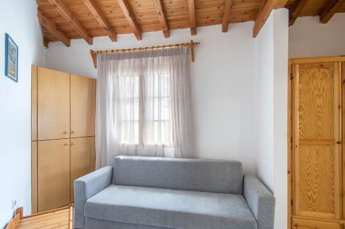 a blue couch in a room with a window at ELIZA Skiathos in Skiathos Town