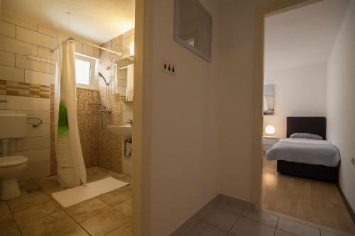 a bathroom with a shower and a toilet and a sink at Aurora Apartments in Bol
