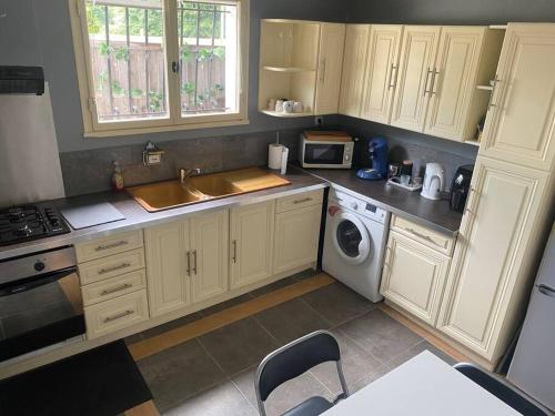 a kitchen with a sink and a washing machine at Appartement relaxant au bassin in La Teste-de-Buch