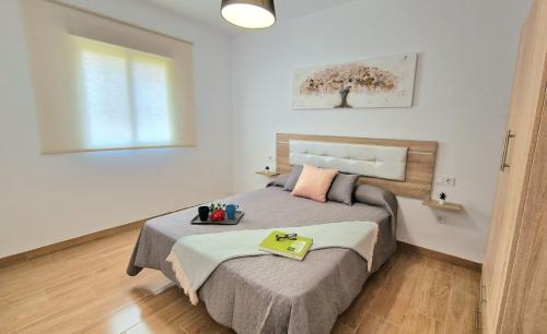 Un dormitorio con una cama con una bandeja encima. en Villa Candari, en Chiclana de la Frontera