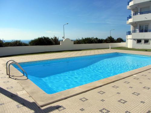 a swimming pool in front of a house at Páteo na Ericeira in Ericeira