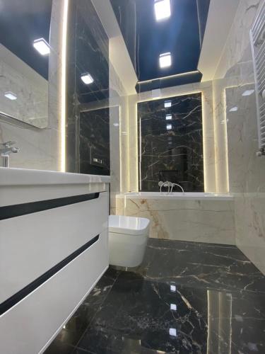 a bathroom with a tub and a cat sitting in a window at Prospekt 1 in Uzhhorod