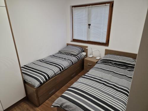 two beds in a small room with a window at S + A in Posedarje