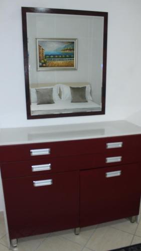 a dresser with a mirror on top of it at Deni's Family Apartment in New BLVD in Tirana