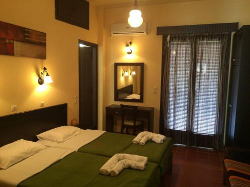 1 dormitorio con 1 cama con 2 toallas en Green Hotel - Maravel Botanical Garden, en Spílion