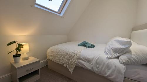 a bedroom with a white bed with a plant on it at Modern spacious apartment in Brighton & Hove