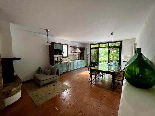 ein Wohnzimmer mit einem Glastisch und eine Küche in der Unterkunft Casa Mimose Rosa in SantʼAngelo in Pontano