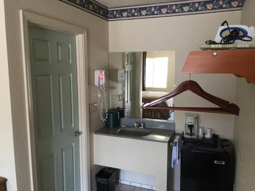 a small kitchen with a sink and a mirror at Budget Inn of Lodi in Lodi