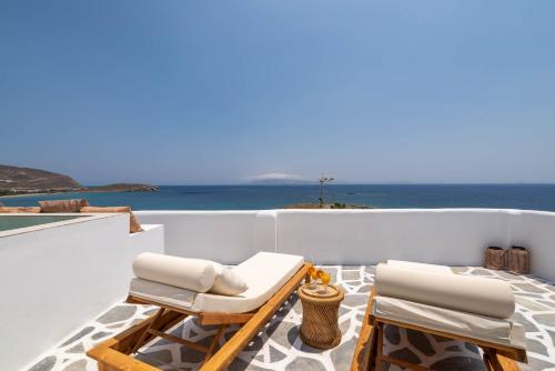 a balcony with chairs and a view of the ocean at Cavos in Agios Sostis