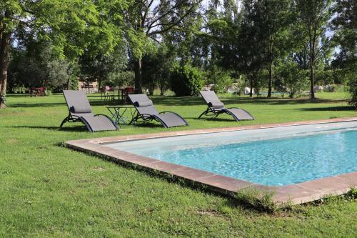 two lounge chairs sitting next to a swimming pool at Le Mas des Cerisiers JACUZZI et SAUNA inclus pour tous les logements in Avignon