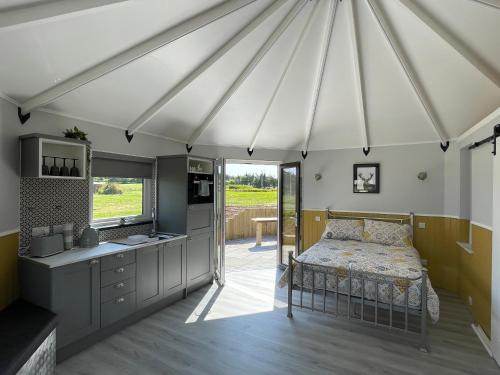 um quarto com uma cama e uma cozinha numa tenda em AC/DC Glamping em New Aberdour