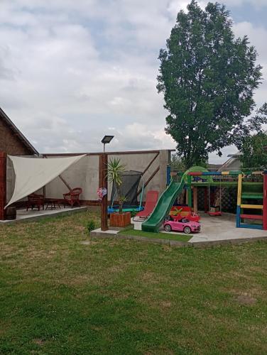 a playground with a slide and a swing set at Casa Ilinca in Filioara