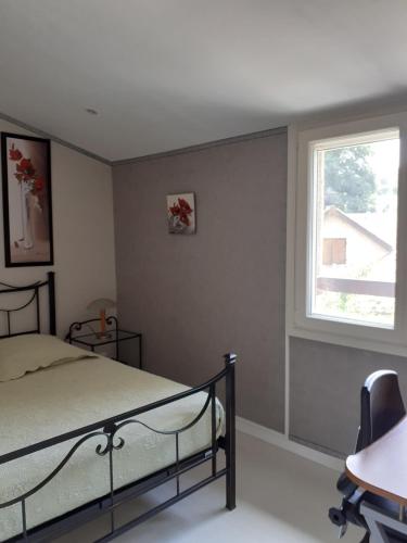 Schlafzimmer mit einem Bett und einem Fenster in der Unterkunft Chambre coquelicots chaleureuse dans un écrin verdoyant 