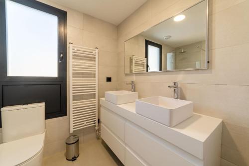 Baño blanco con 2 lavabos y espejo en Apartamento Nuevo Alexia 1 4 1 en Calpe, en Calpe