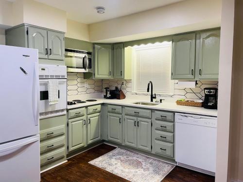 a kitchen with green cabinets and white appliances at Newly renovated charming home with parking in Fort Washington