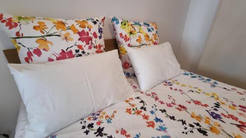 Alba di luna في سانتا تيريزا دي ريفا: وسادتين على سرير مع وسائد الزهور